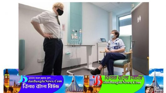 বসে কথা বলছেন নার্স, দাঁড়িয়ে থেকে শুনছেন ব্রিটিশ প্রধানমন্ত্রী